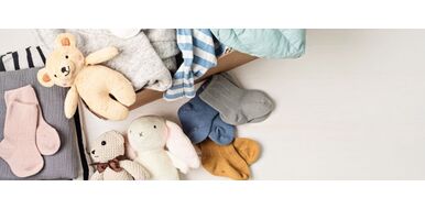 An organised shelf with eco-friendly storage bins filled with preloved baby toys, books, and clothes. The image reflects the purpose of decluttering with sustainability in mind, featuring soft earthy tones, wooden accents, and natural textures.